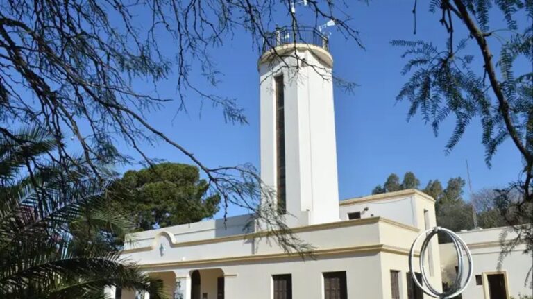 Personas con paraguas abrazando el edificio del Museo Meteorológico Nacional en Córdoba