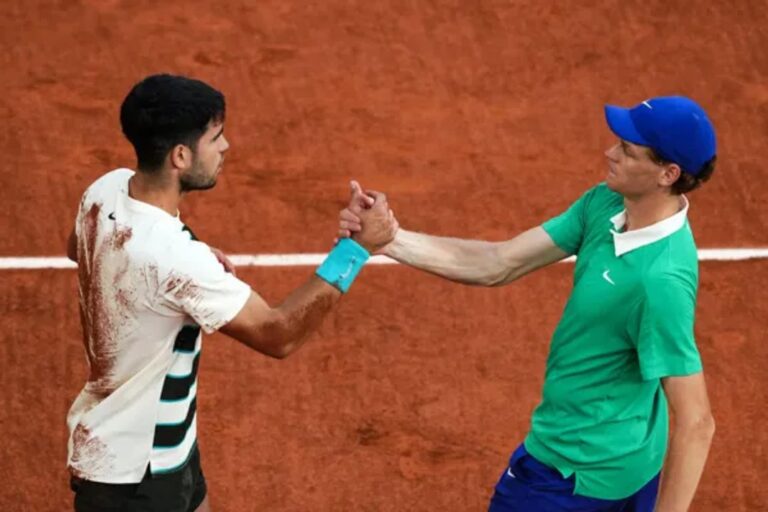 Carlos Alcaraz y Jannik Sinner durante un partido de tenis en arcilla.