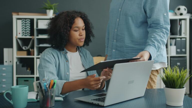 Personas colaborando en documentos digitales en una oficina moderna