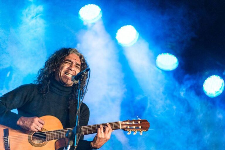 Escena del documental Pulsando la vida con Marcelino Azaguate tocando un instrumento andino en un paisaje de Cuyo