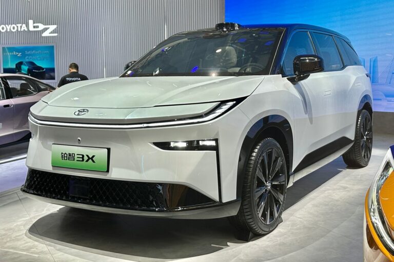 Vista frontal del nuevo Toyota bZ3X, SUV eléctrico de color gris, en un entorno urbano.