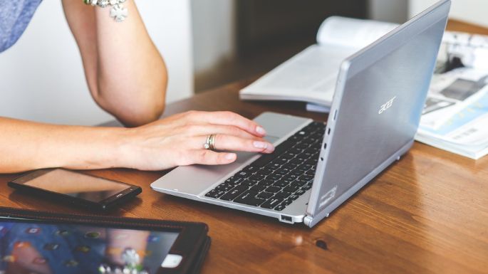 Persona usando una laptop con íconos de emprendimiento y finanzas