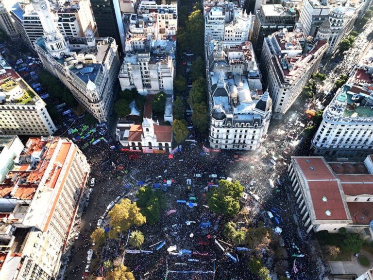 Manifestantes con carteles en la Marcha Federal Universitaria en Buenos Aires, con banderas de universidades nacionales