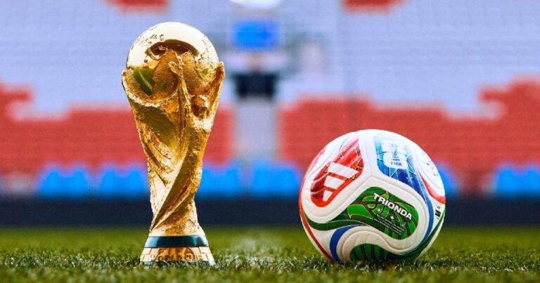 Balón de fútbol sobre fondo de banderas de Estados Unidos, México y Canadá