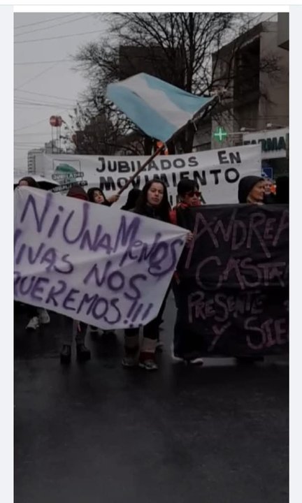 Personas marchando en una calle de Argentina con carteles de protesta