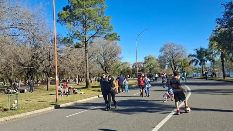 Vista de la costanera del lago San Roque con personas realizando actividades al aire libre
