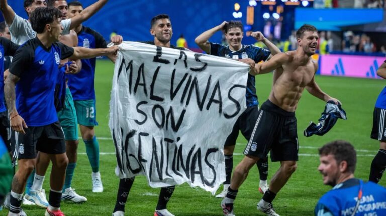 Bandera con inscripción Las Malvinas son Argentinas desplegada por futbolistas argentinos
