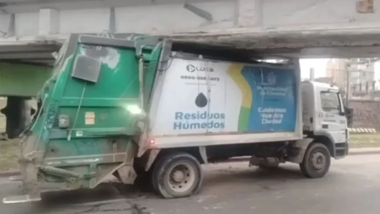 Camión de recolección de residuos atascado bajo un puente ferroviario en la costanera de Córdoba